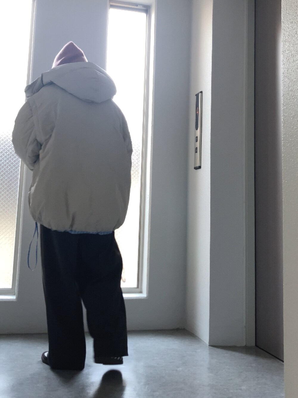 ブルー系のダウンジャケット/コート、ホワイト系のニット/セーター、ブラック系のバッグを着用したレディースの冬コーディネートの5枚目の写真