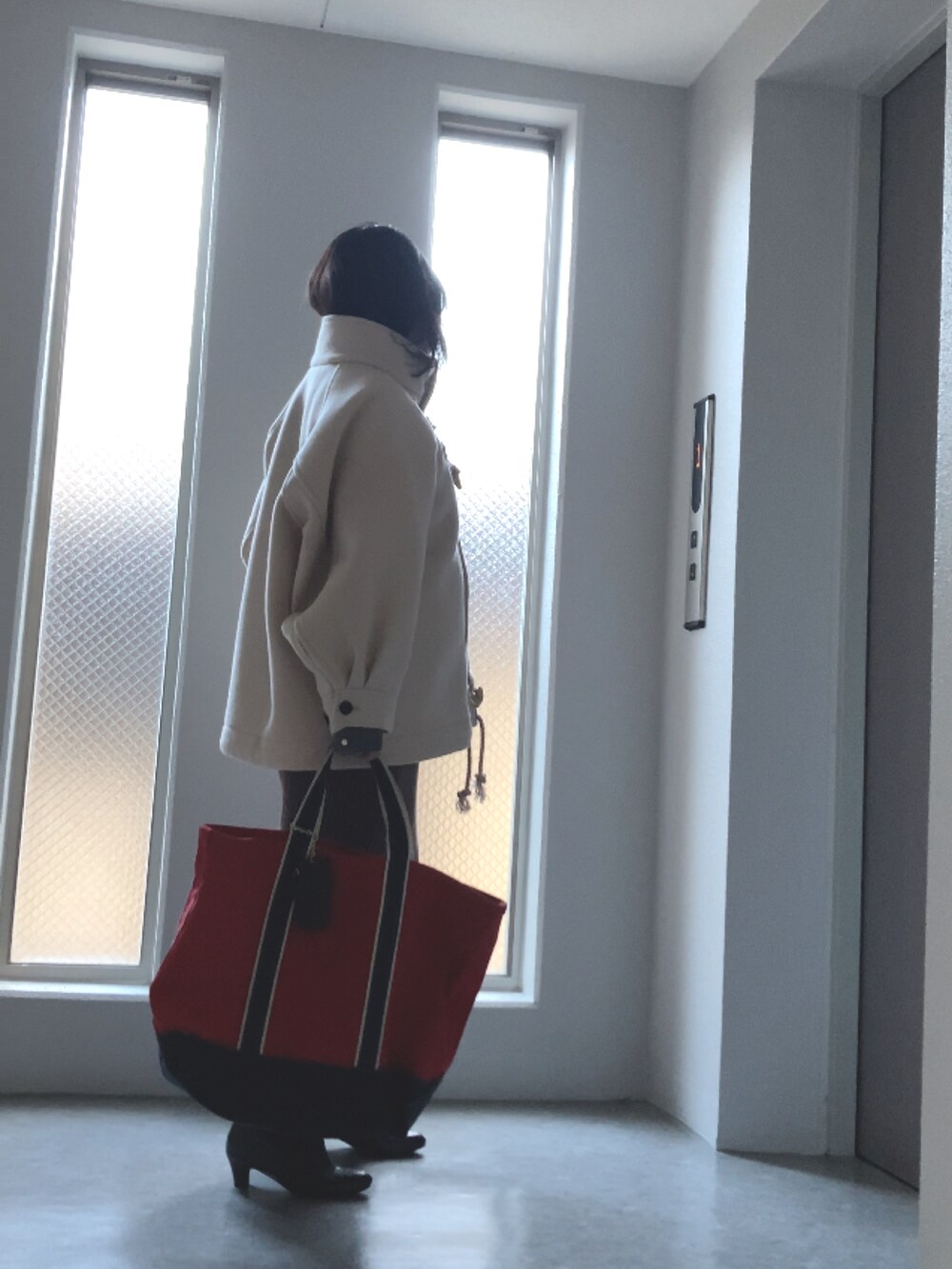 グレー系のニット/セーター、ブラウン系のスカート、ブラウン系のブーツを着用したレディースの冬コーディネートの3枚目の写真