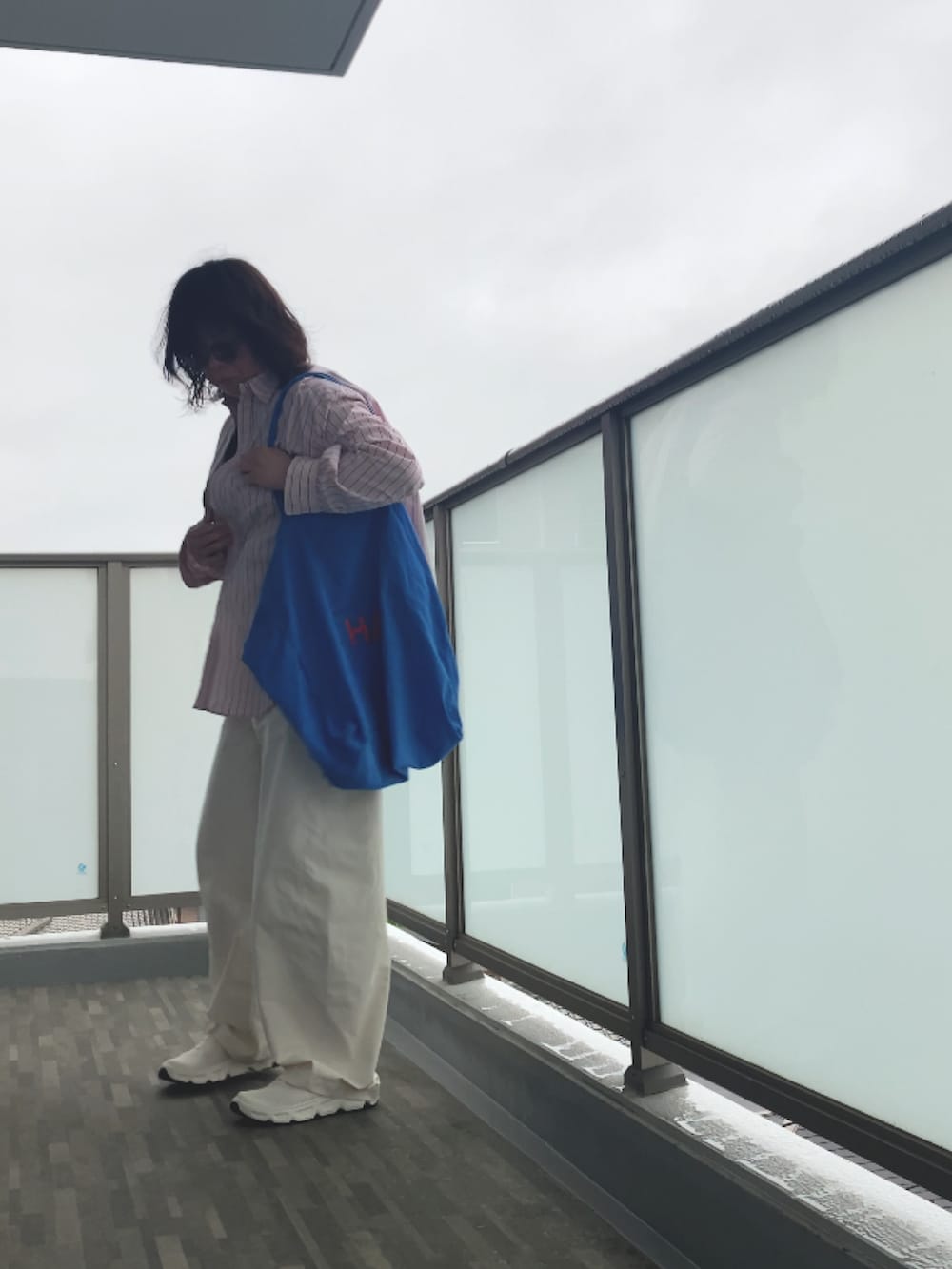 ホワイト系のサンダル、ホワイト系のタンクトップ、ホワイト系のパンツを着用したレディースの春コーディネートの4枚目の写真