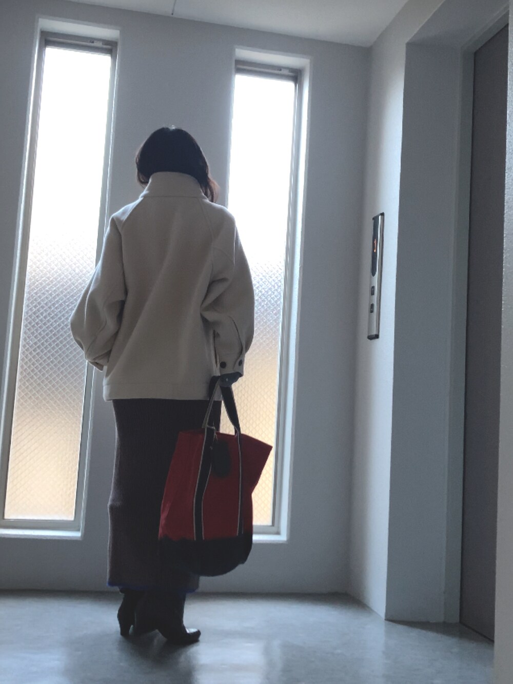 グレー系のニット/セーター、ブラウン系のスカート、ブラウン系のブーツを着用したレディースの冬コーディネートの5枚目の写真