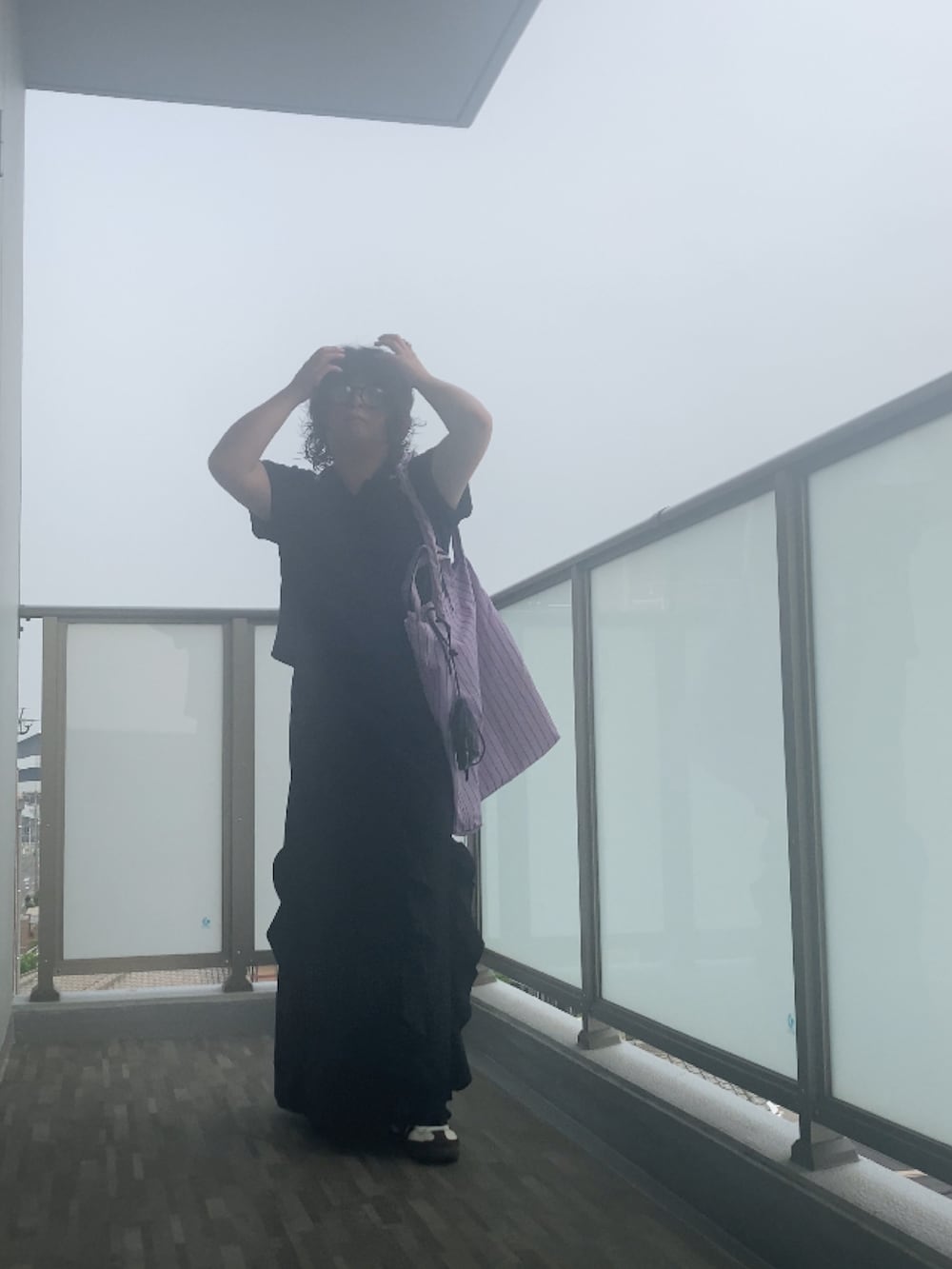 ブラック系のスカート、パープル系のトートバッグ、ブラック系のショルダーバッグを着用したレディースの夏コーディネートの2枚目の写真