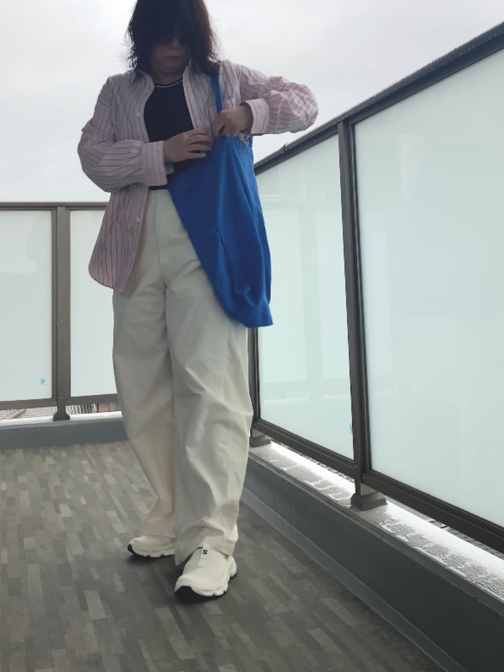 ホワイト系のサンダル、ホワイト系のタンクトップ、ホワイト系のパンツを着用したレディースの春コーディネートの5枚目の写真