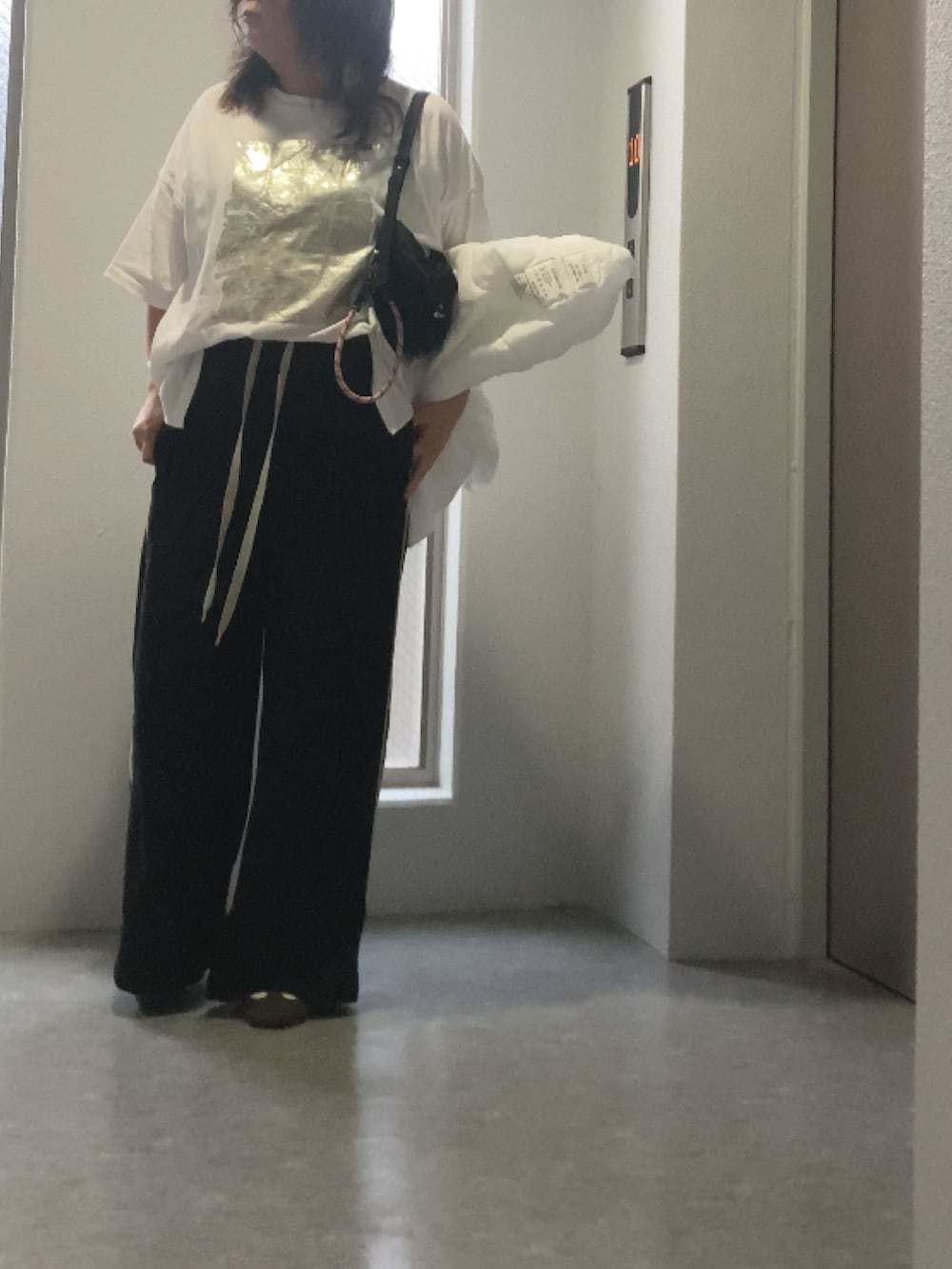 ホワイト系のスニーカー、ブラック系のバッグ、ブラック系のその他パンツを着用したレディースの秋コーディネートの2枚目の写真