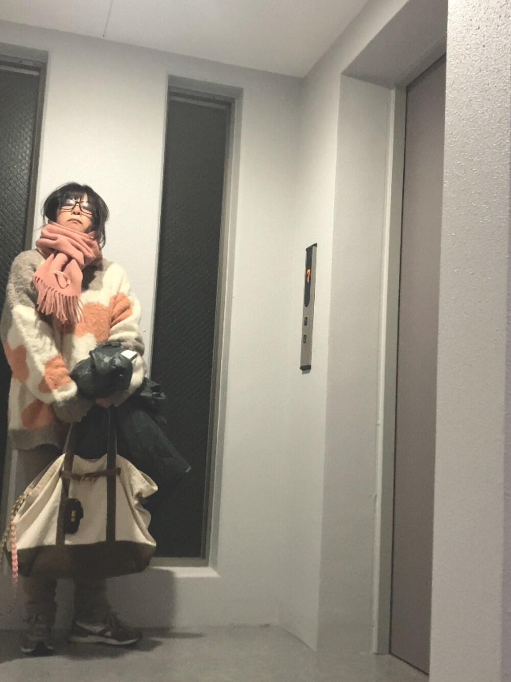 ベージュ系のニット/セーター、グリーン系のトートバッグ、ホワイト系のスニーカーを着用したレディースの冬コーディネートの3枚目の写真