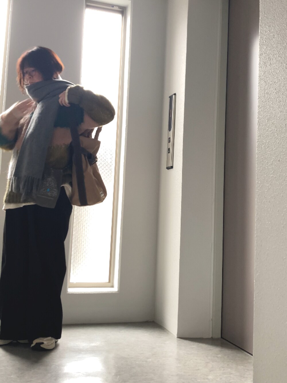 ホワイト系のTシャツ/カットソー、ブラック系のその他パンツ、グリーン系のニット/セーターを着用したレディースの冬コーディネートの5枚目の写真