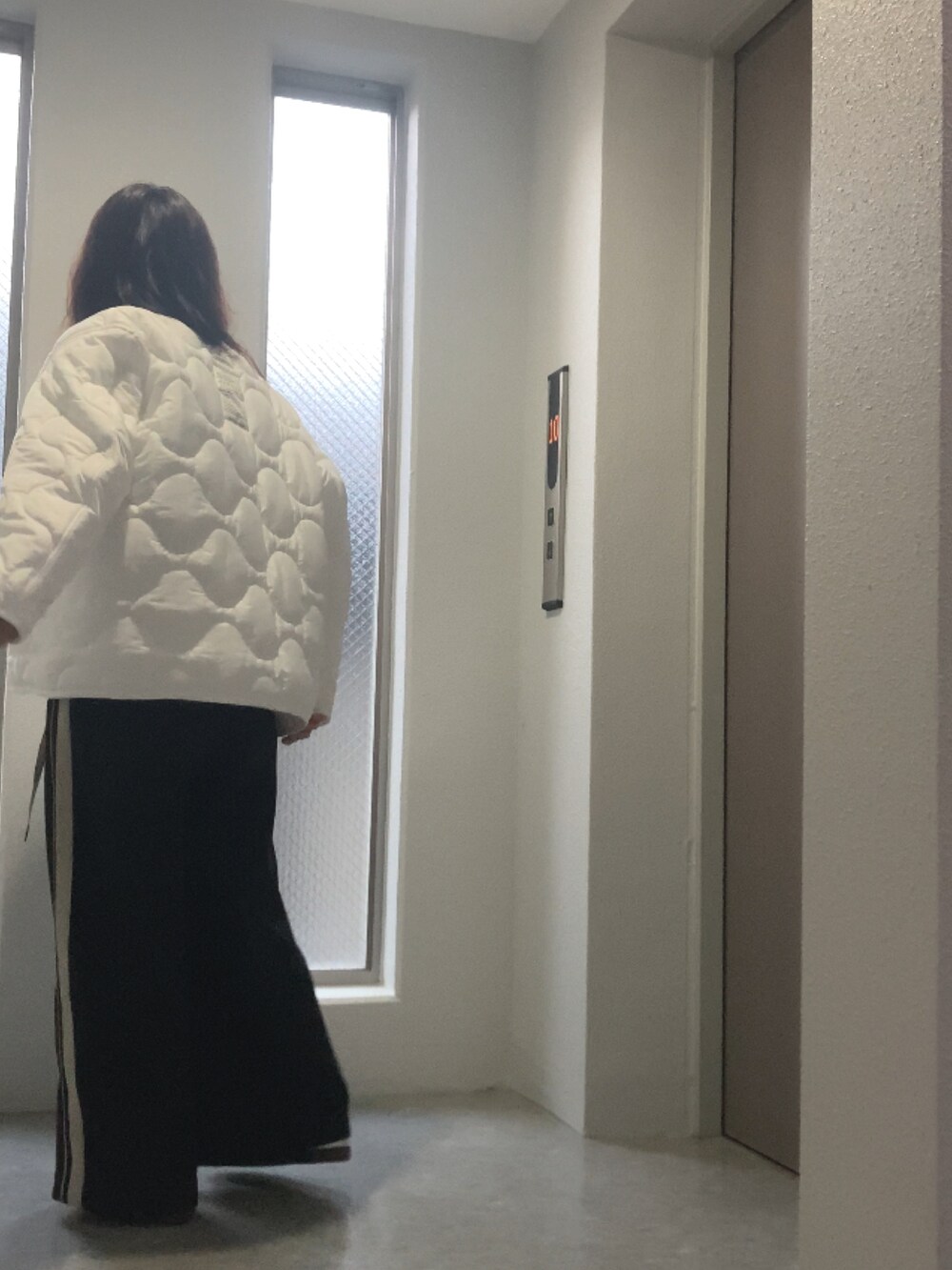 ホワイト系のスニーカー、ブラック系のバッグ、ブラック系のその他パンツを着用したレディースの秋コーディネートの4枚目の写真