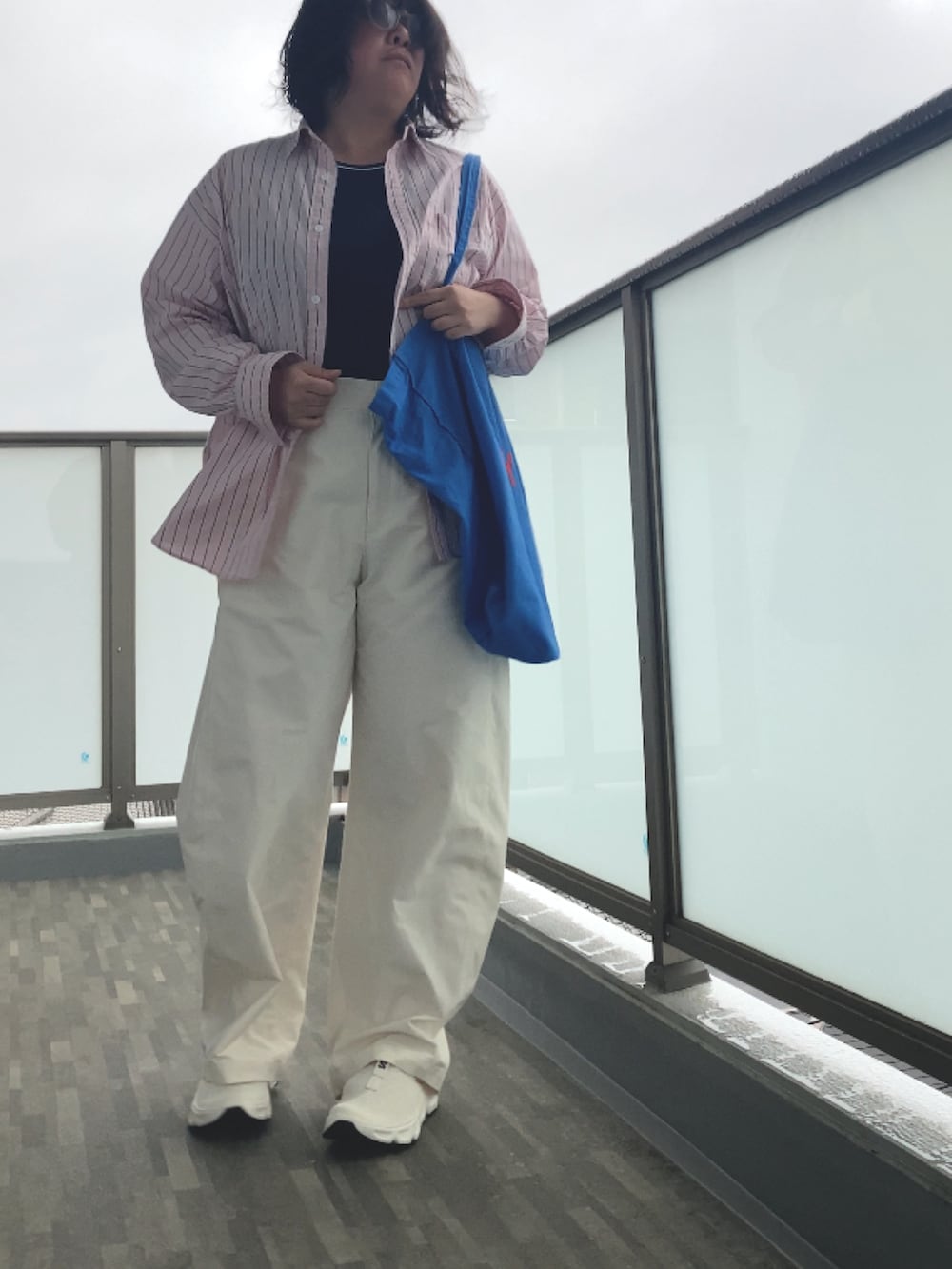 ホワイト系のサンダル、ホワイト系のタンクトップ、ホワイト系のパンツを着用したレディースの春コーディネートの2枚目の写真