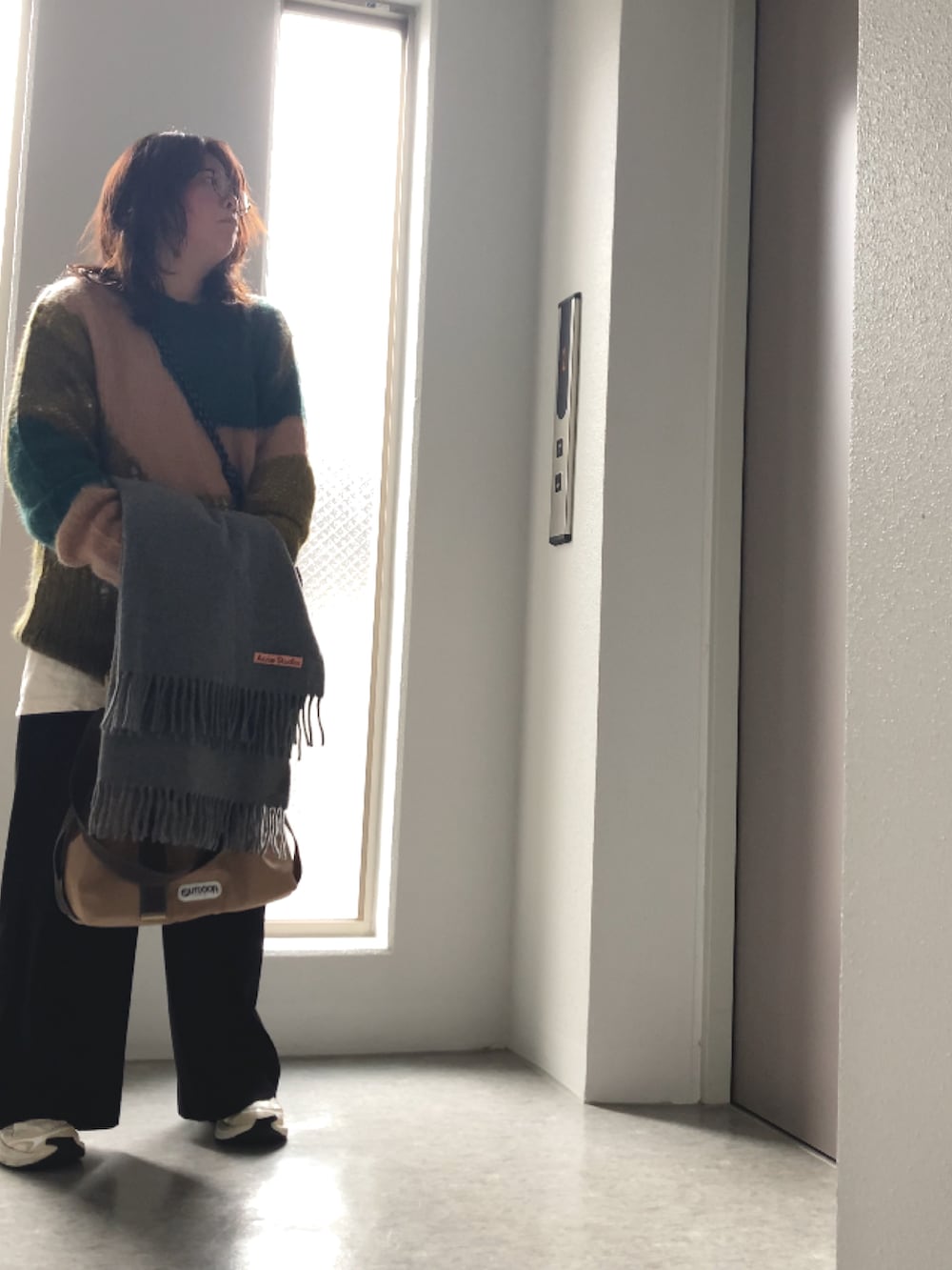 ホワイト系のTシャツ/カットソー、ブラック系のその他パンツ、グリーン系のニット/セーターを着用したレディースの冬コーディネートの4枚目の写真