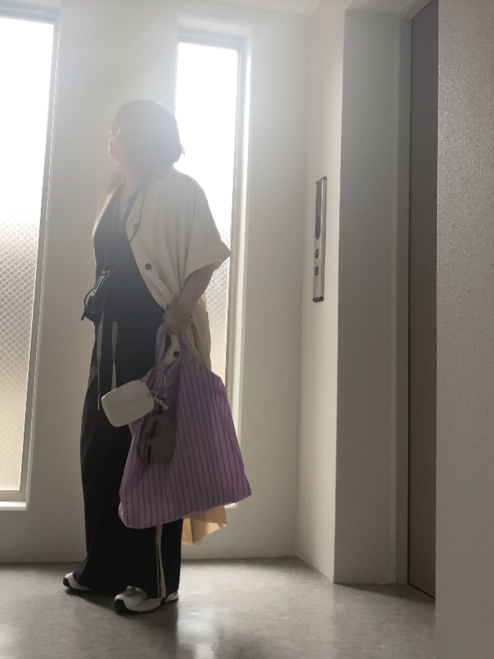 ブラック系のショルダーバッグ、ベージュ系のバックパック/リュック、ブラック系のその他パンツを着用したレディースの秋コーディネートの2枚目の写真