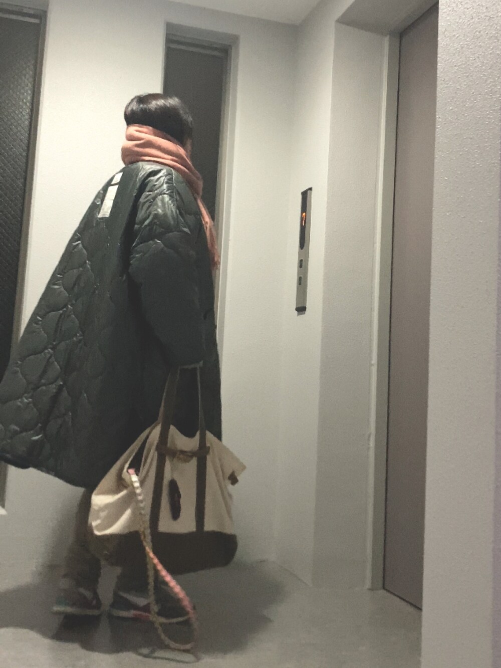 ベージュ系のニット/セーター、グリーン系のトートバッグ、ホワイト系のスニーカーを着用したレディースの冬コーディネートの4枚目の写真