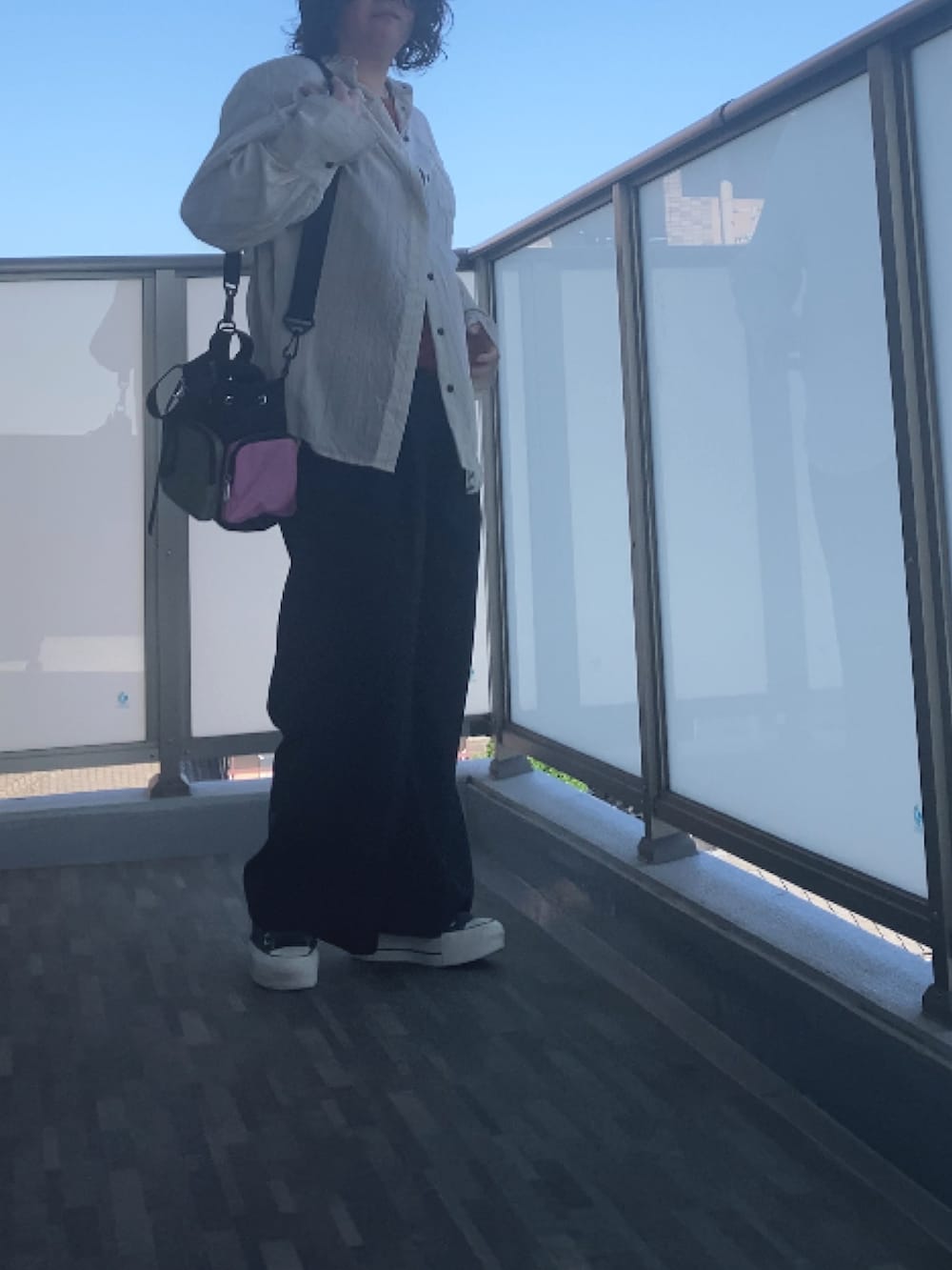 ホワイト系のシャツ/ブラウス、オレンジ系のTシャツ/カットソー、ブラック系のスラックスを着用したレディースの夏コーディネートの3枚目の写真