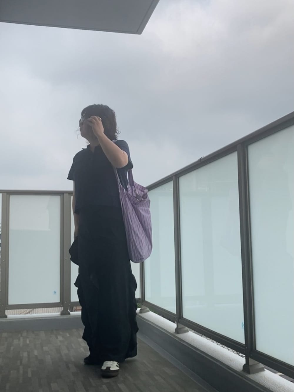 ブラック系のスカート、パープル系のトートバッグ、ブラック系のショルダーバッグを着用したレディースの夏コーディネートの5枚目の写真