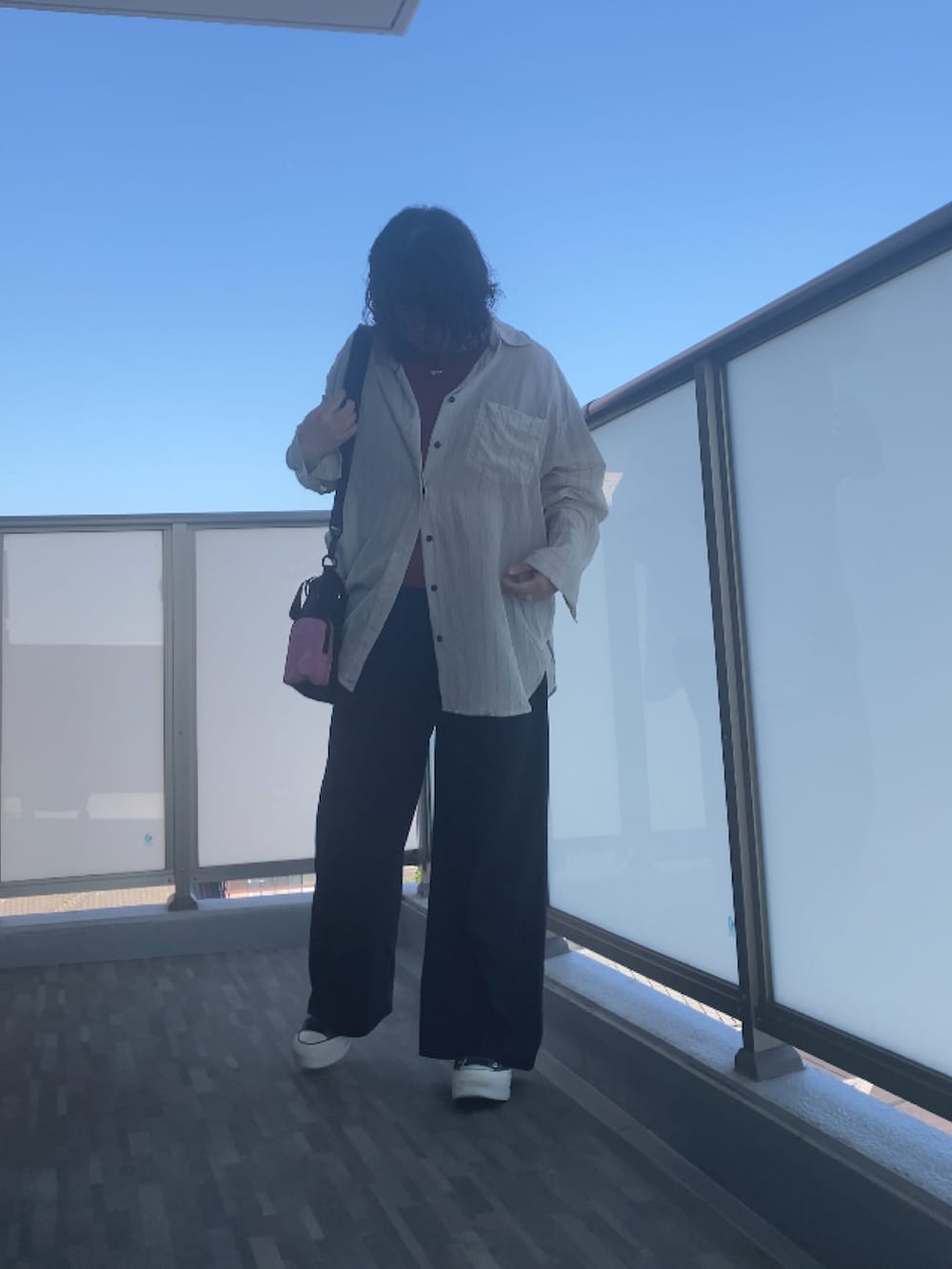 ホワイト系のシャツ/ブラウス、オレンジ系のTシャツ/カットソー、ブラック系のスラックスを着用したレディースの夏コーディネートの4枚目の写真