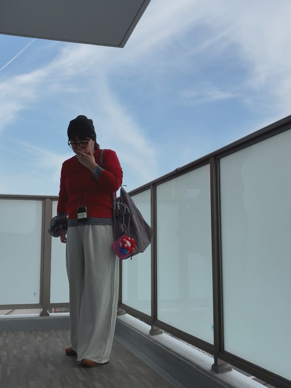 グレー系のその他パンツ、ブラウン系のショルダーバッグ、ベージュ系のスニーカーを着用したレディースの秋コーディネートの4枚目の写真