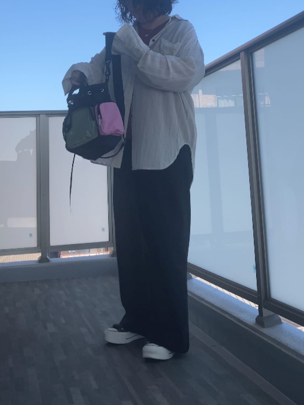 ホワイト系のシャツ/ブラウス、オレンジ系のTシャツ/カットソー、ブラック系のスラックスを着用したレディースの夏コーディネートの5枚目の写真