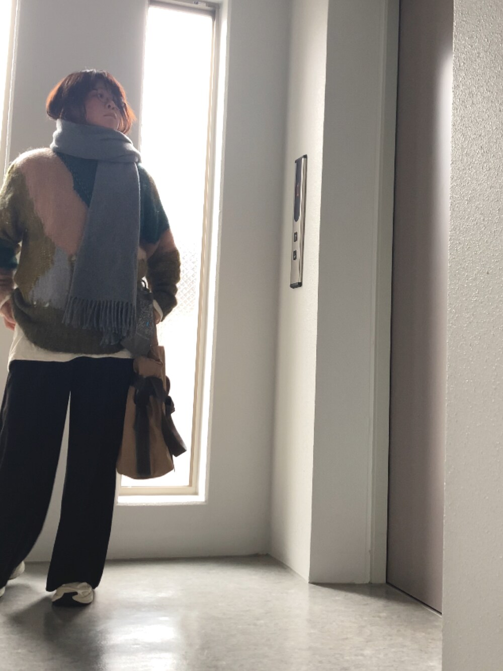 ホワイト系のTシャツ/カットソー、ブラック系のその他パンツ、グリーン系のニット/セーターを着用したレディースの冬コーディネートの2枚目の写真