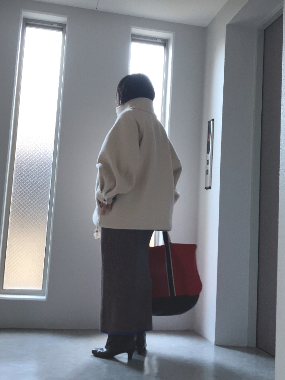 グレー系のニット/セーター、ブラウン系のスカート、ブラウン系のブーツを着用したレディースの冬コーディネートの4枚目の写真