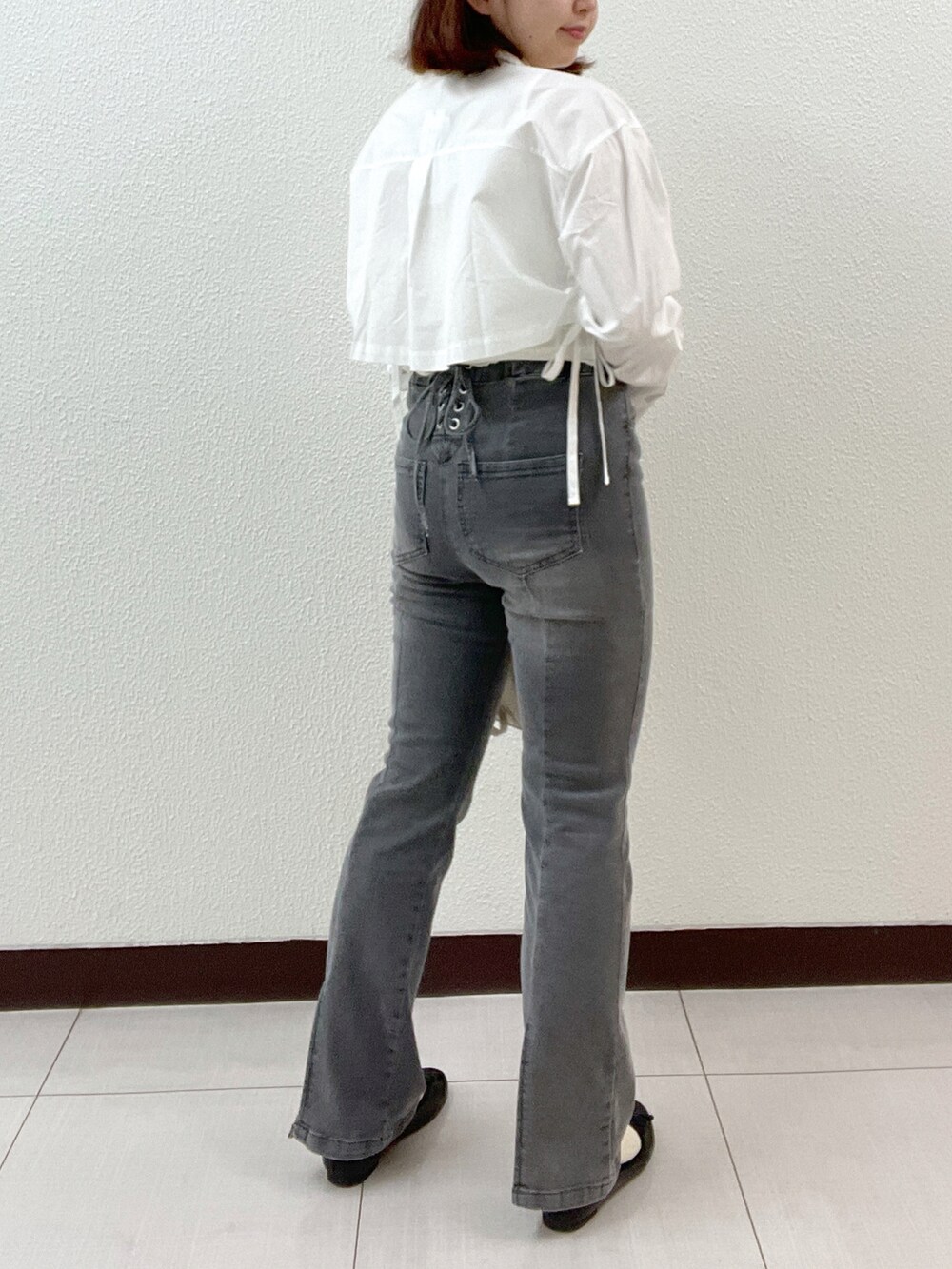 ブラック系のデニムパンツ、ホワイト系のシャツ/ブラウス、ホワイト系のタンクトップを着用したレディースの春コーディネートの2枚目の写真