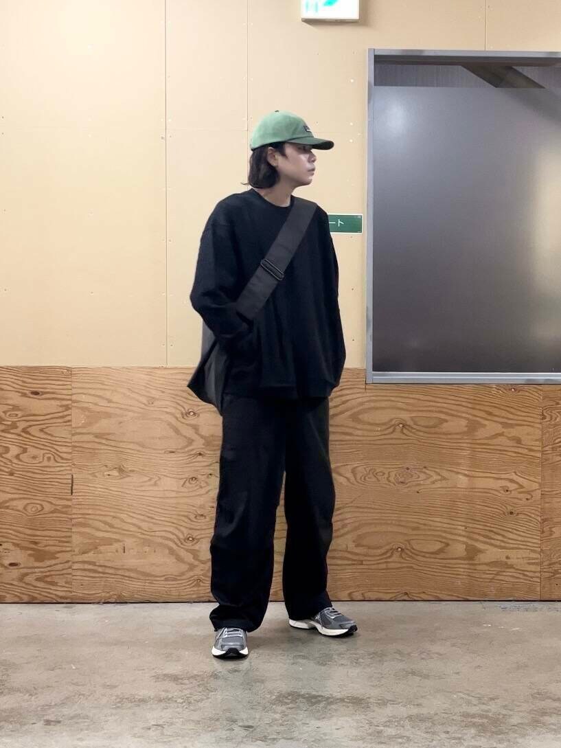 グレー系のショルダーバッグ、グレー系のスニーカー、ブラック系のその他パンツを着用したメンズの秋コーディネートの2枚目の写真