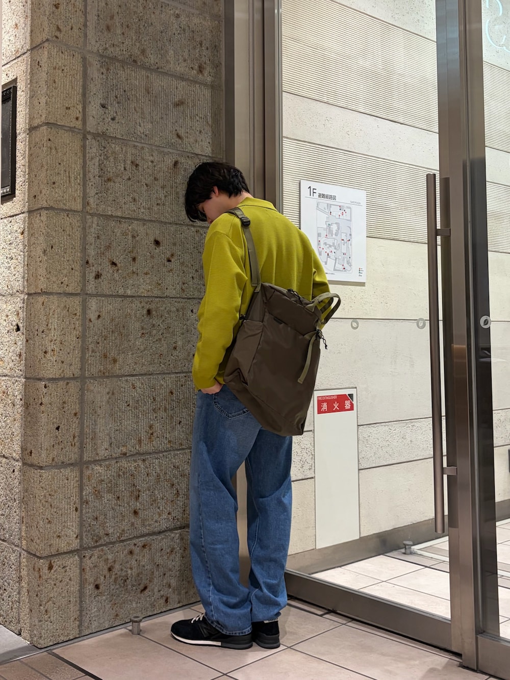 イエロー系のカーディガン/ボレロ、グレー系のTシャツ/カットソー、ブルー系のデニムパンツを着用したメンズの春コーディネートの2枚目の写真