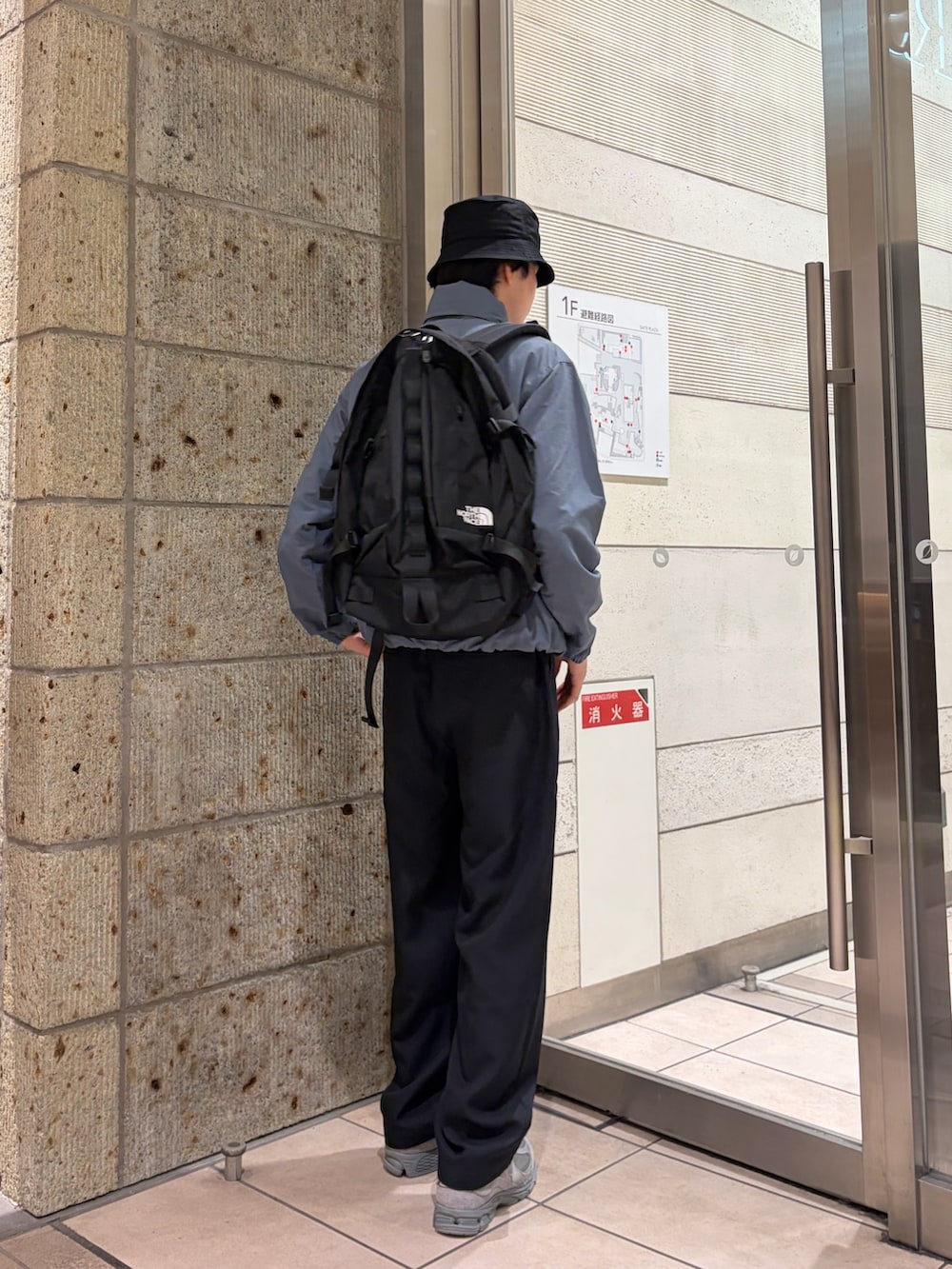 グレー系のブルゾン、ブルー系のその他パンツ、ブラック系のバックパック/リュックを着用したメンズの春コーディネートの4枚目の写真