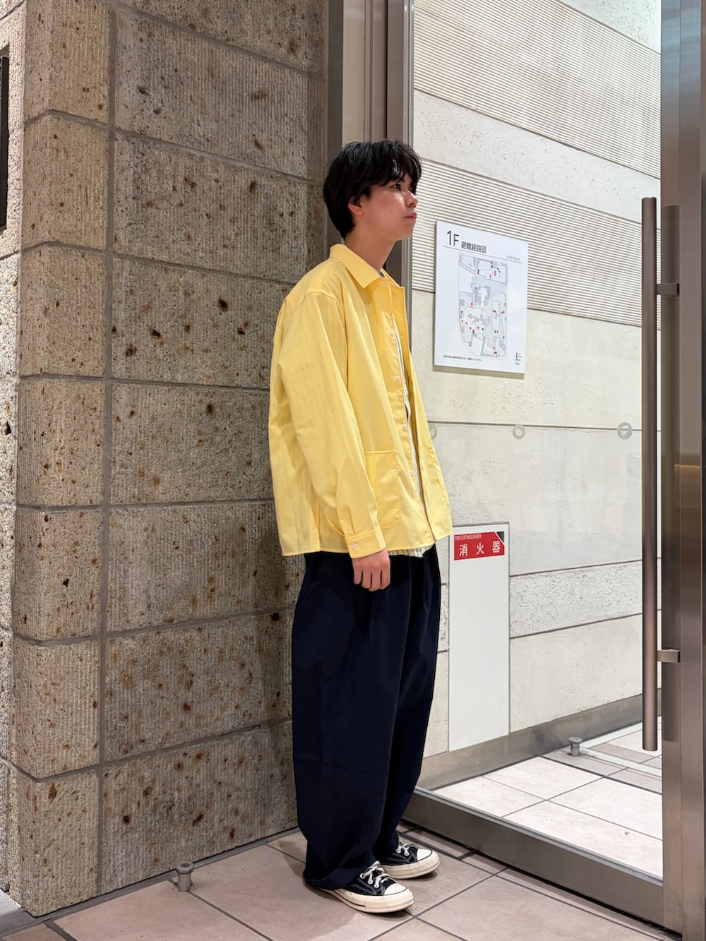 ブラック系のスニーカー、イエロー系のカバーオール、ブルー系のその他パンツを着用したメンズの春コーディネートの5枚目の写真