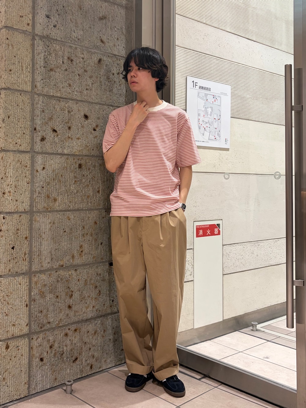 レッド系のTシャツ/カットソー、ベージュ系のその他パンツ、ブラック系のスニーカーを着用したメンズの春コーディネートの2枚目の写真