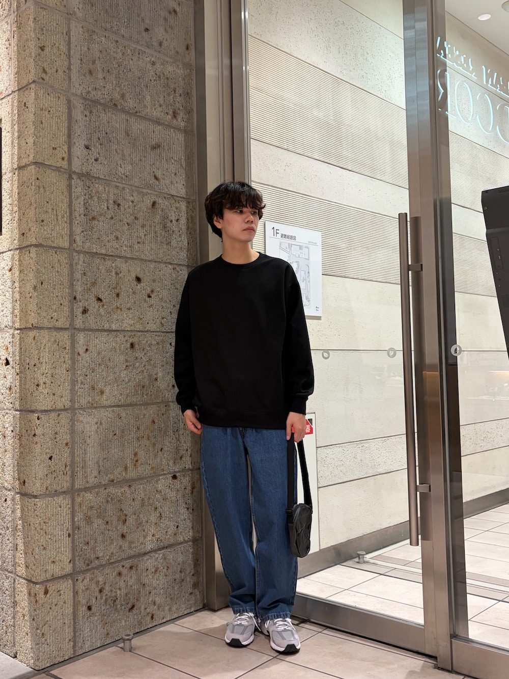 ブラック系のTシャツ/カットソー、ブルー系のデニムパンツ、グレー系のスニーカーを着用したメンズの冬コーディネートの2枚目の写真