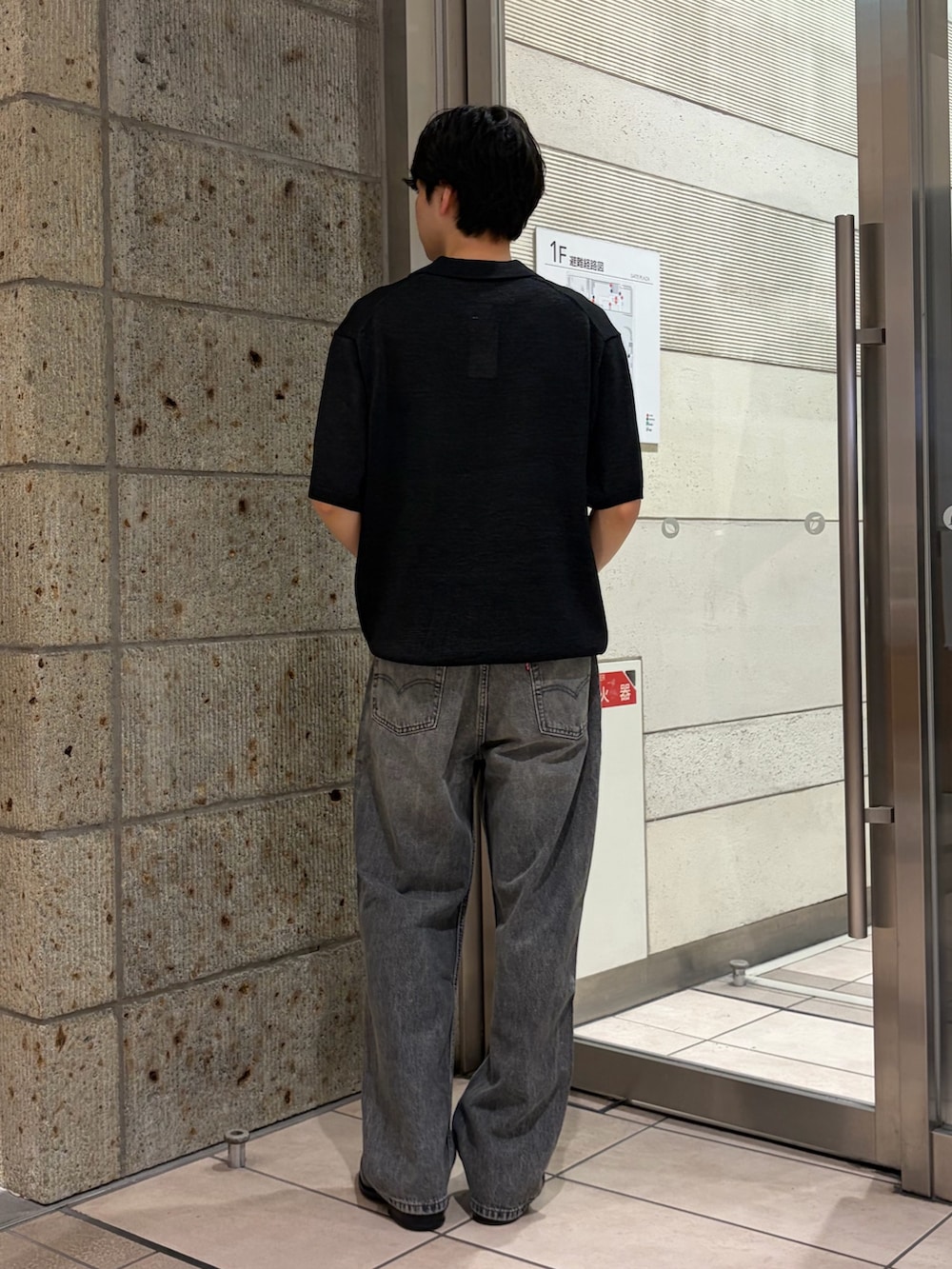ブラック系のニット/セーター、ブラック系のデニムパンツ、ブラック系のドレスシューズを着用したメンズの夏コーディネートの3枚目の写真