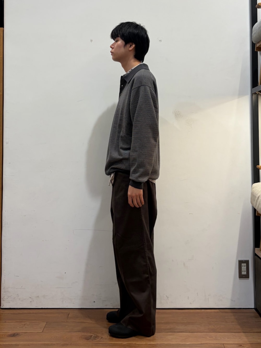 グレー系のニット/セーター、ホワイト系のシャツ/ブラウス、ブラウン系のその他パンツを着用したメンズの秋コーディネートの4枚目の写真