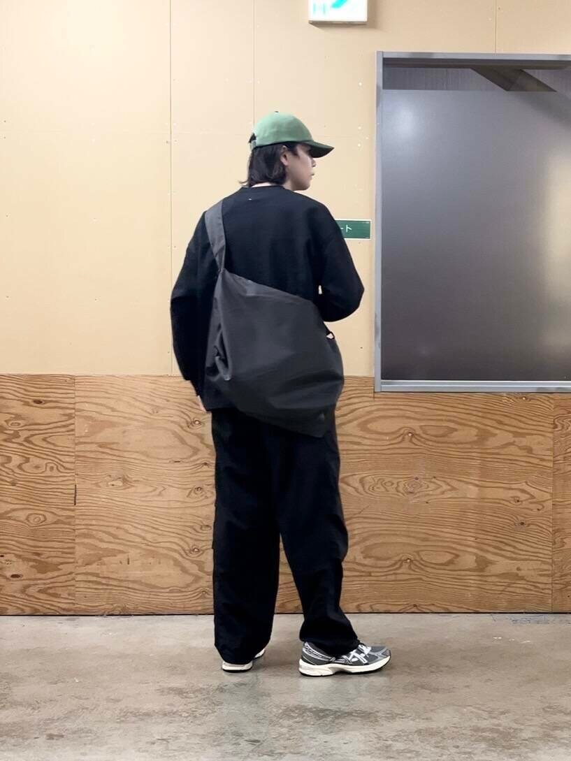 グレー系のショルダーバッグ、グレー系のスニーカー、ブラック系のその他パンツを着用したメンズの秋コーディネートの3枚目の写真