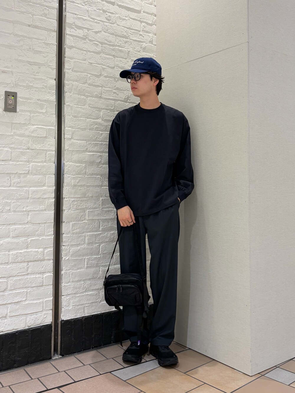 グレー系のTシャツ/カットソー、ブラック系のショルダーバッグ、ブラック系のスニーカーを着用したメンズの春コーディネートの2枚目の写真