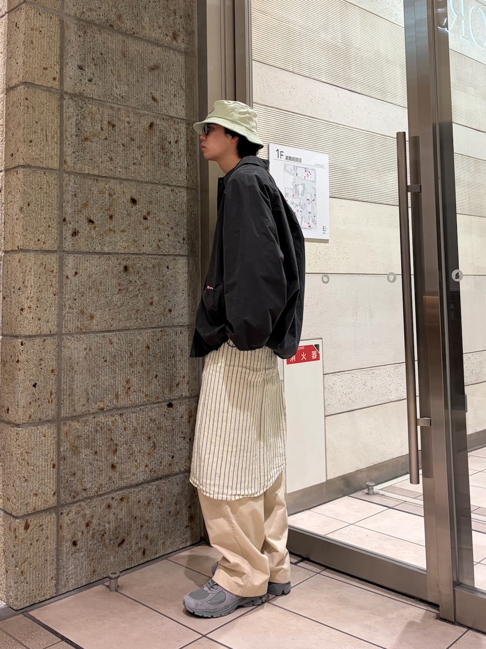 ブラック系のブルゾン、ブルー系のニット/セーター、イエロー系のシャツ/ブラウスを着用したメンズの春コーディネートの4枚目の写真