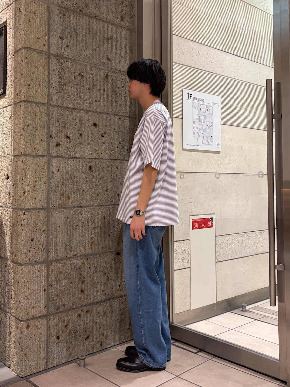 ブルー系のデニムパンツ、ブラック系のドレスシューズ、ピンク系のTシャツ/カットソーを着用したメンズの春コーディネートの2枚目の写真