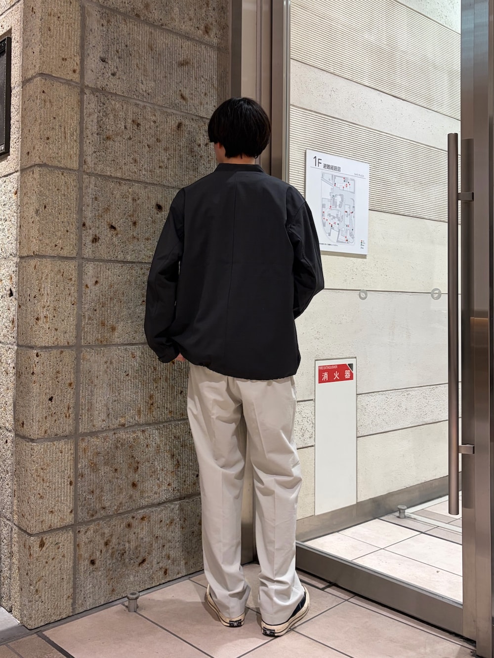 ブラック系のTシャツ/カットソー、ホワイト系のその他パンツ、ブラック系のスニーカーを着用したメンズの春コーディネートの5枚目の写真