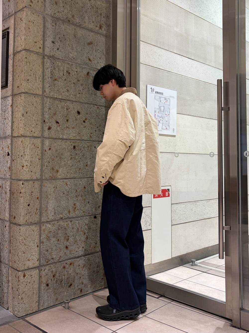 ホワイト系のカバーオール、グレー系のスウェット、ブルー系のデニムパンツを着用したメンズの冬コーディネートの4枚目の写真