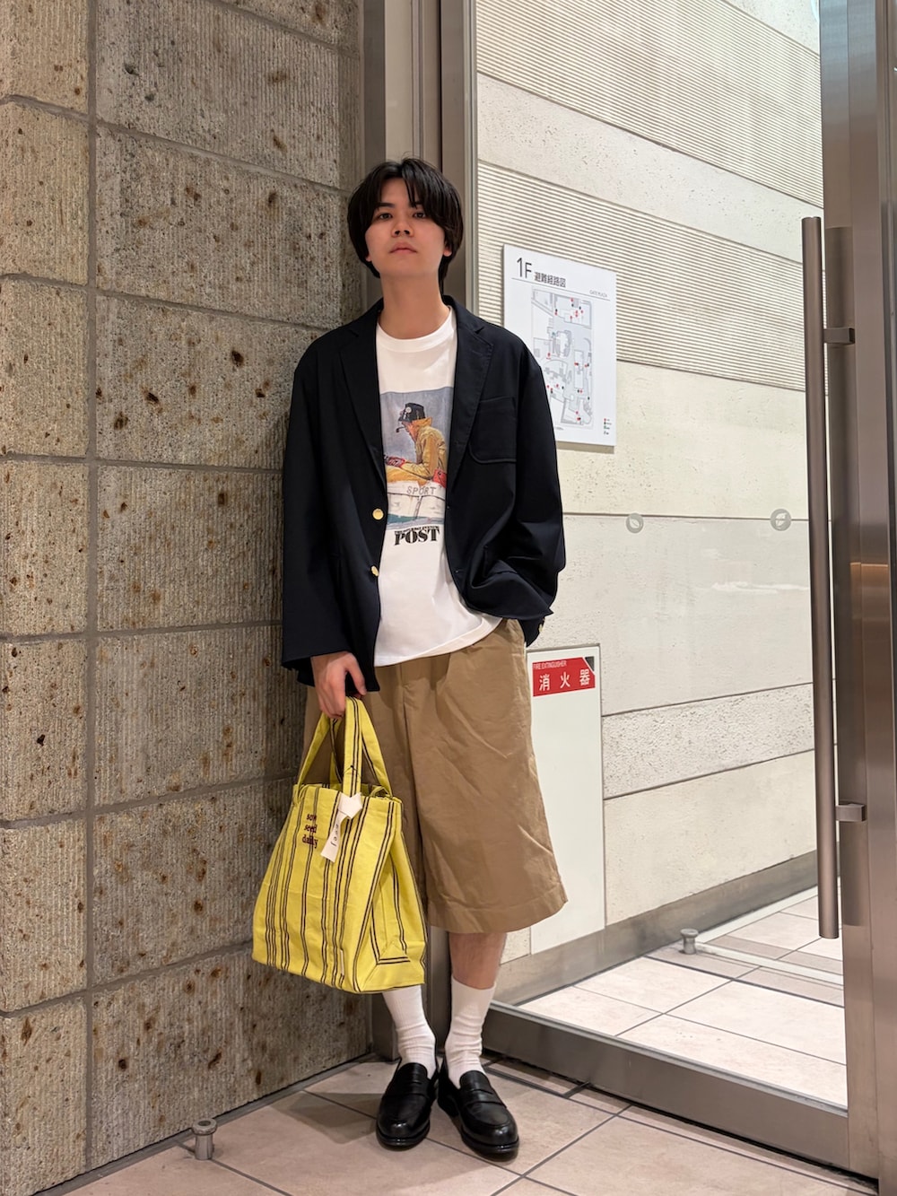 ベージュ系のその他パンツ、イエロー系のトートバッグ、ブラック系のドレスシューズを着用したメンズの春コーディネートの2枚目の写真