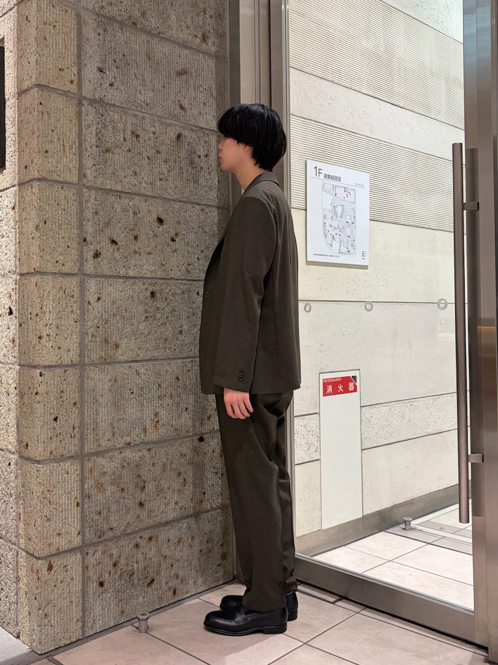 ブラウン系のその他アウター、グレー系のシャツ/ブラウス、ブラウン系のスーツパンツを着用したメンズの春コーディネートの3枚目の写真