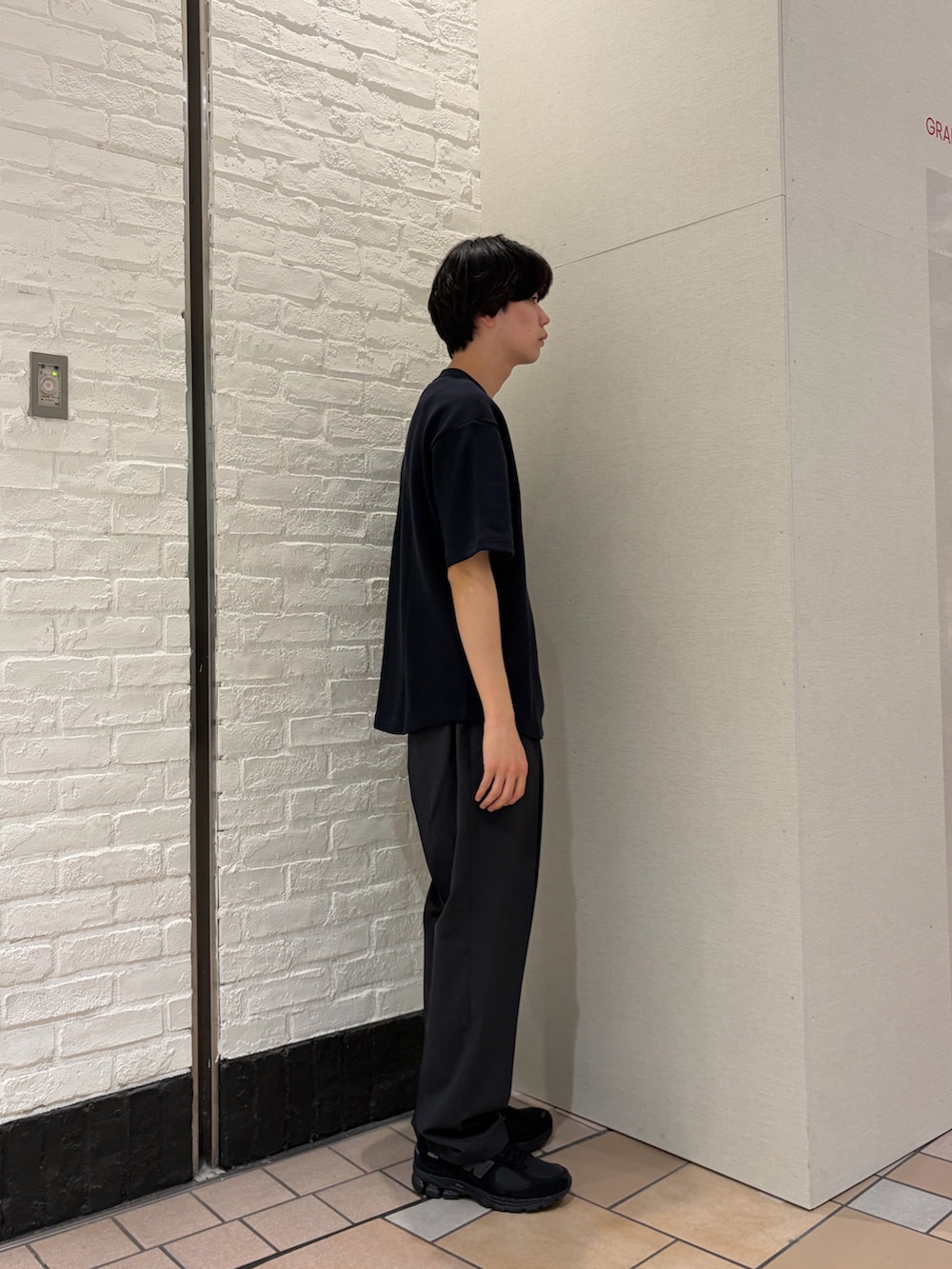 ブルー系のTシャツ/カットソー、グレー系のその他パンツ、ブラック系のスニーカーを着用したメンズの春コーディネートの5枚目の写真