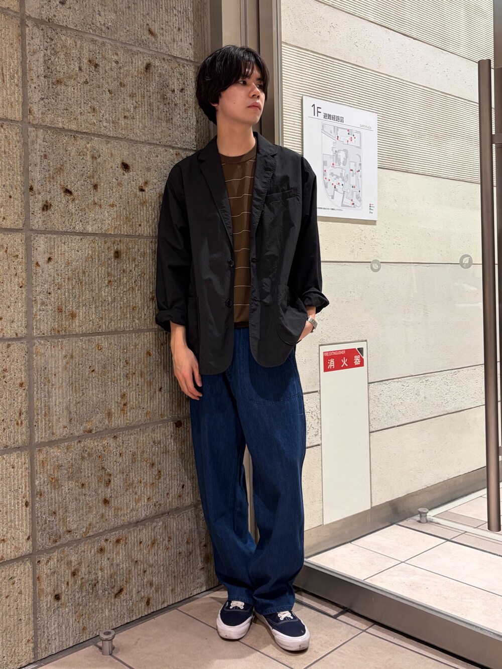 ブラック系のその他アウター、ブラウン系のニット/セーター、ブルー系のデニムパンツを着用したメンズの春コーディネートの3枚目の写真