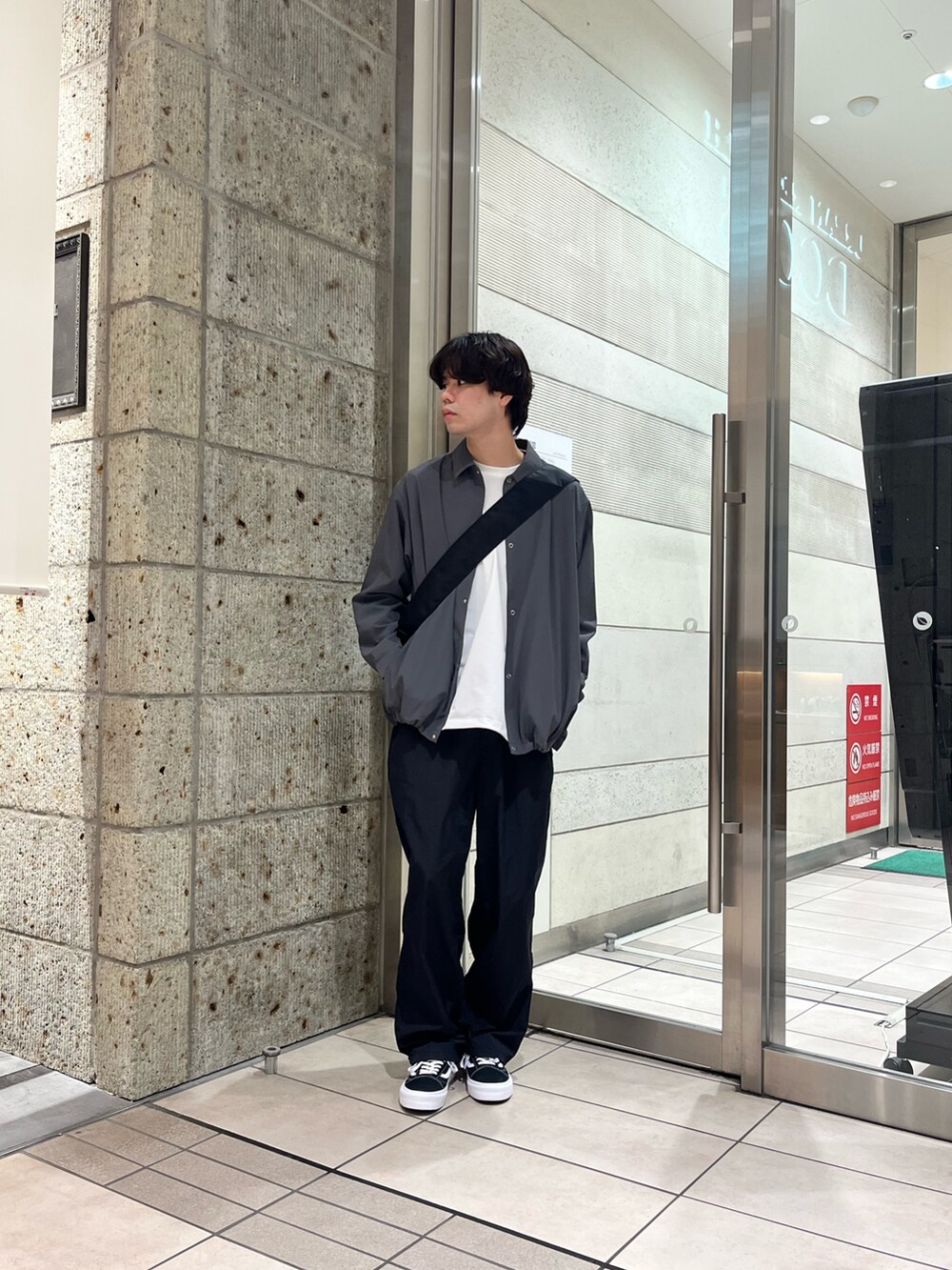 ブラック系のその他パンツ、ブラック系のスニーカー、ホワイト系のTシャツ/カットソーを着用したメンズの秋コーディネートの2枚目の写真