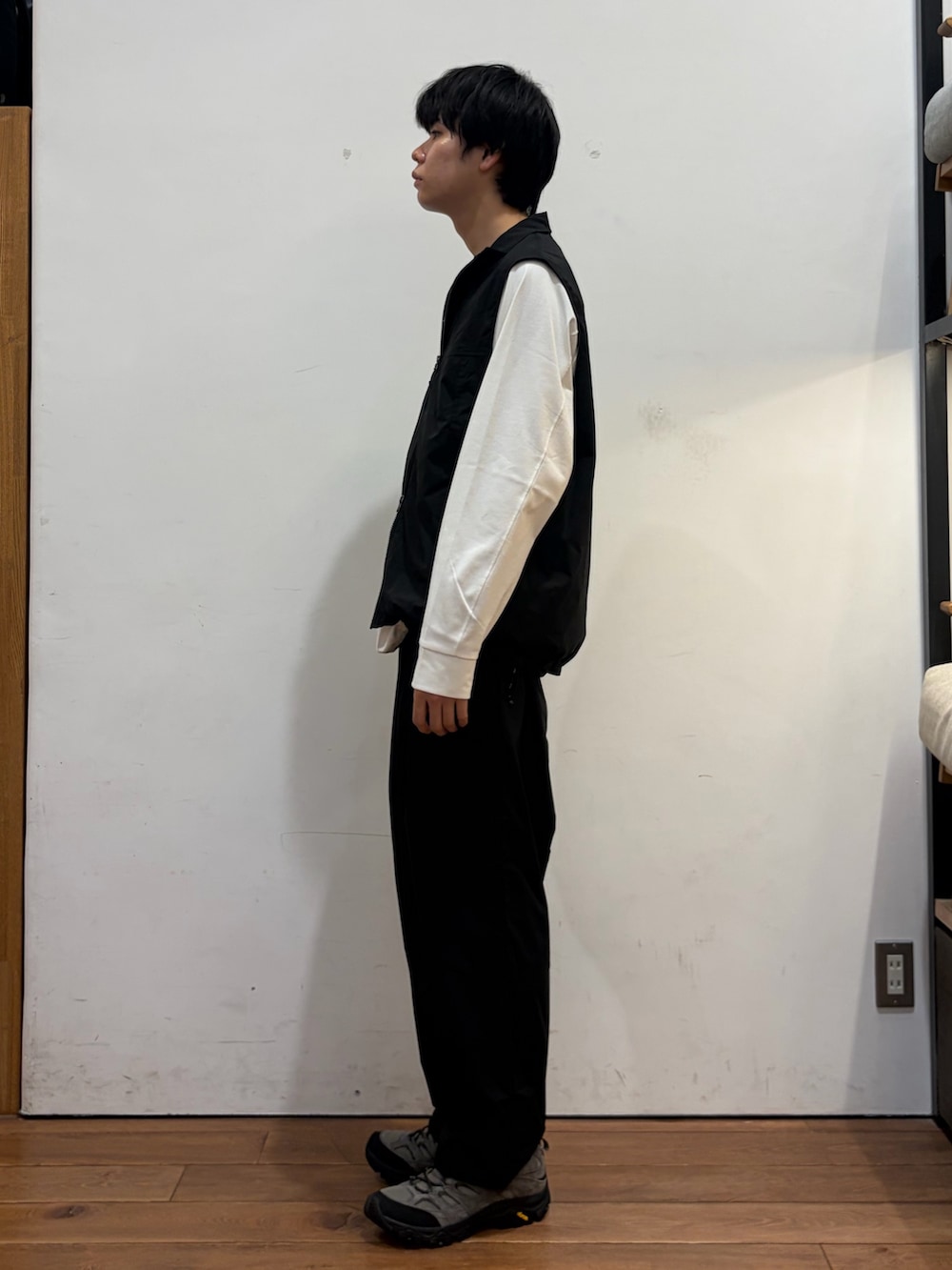 ブラック系のベスト、ホワイト系のTシャツ/カットソー、ブラック系のその他パンツを着用したメンズの秋コーディネートの2枚目の写真