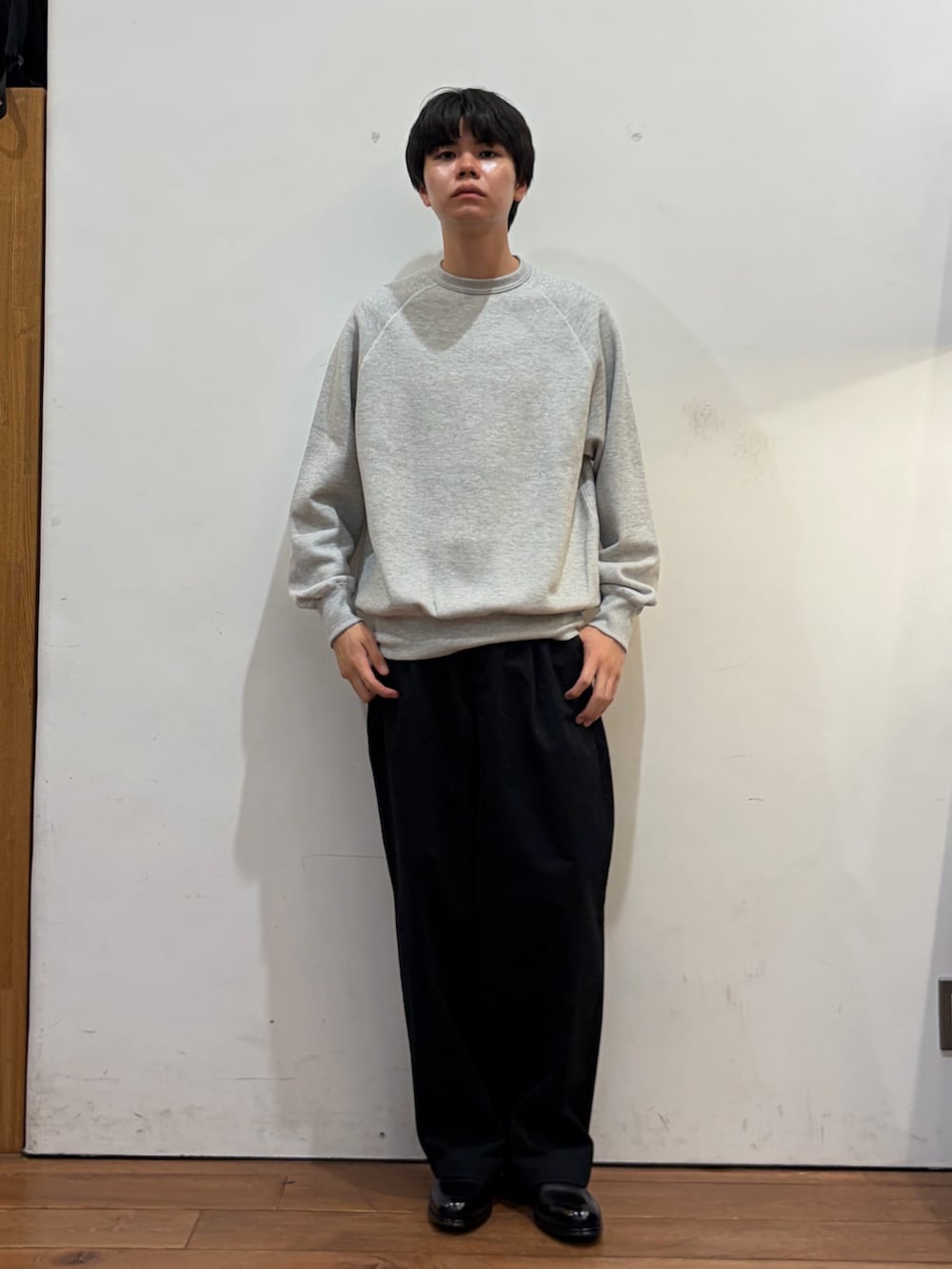 グレー系のスウェット、ブルー系のその他パンツ、ブラック系のドレスシューズを着用したメンズの秋コーディネートの2枚目の写真
