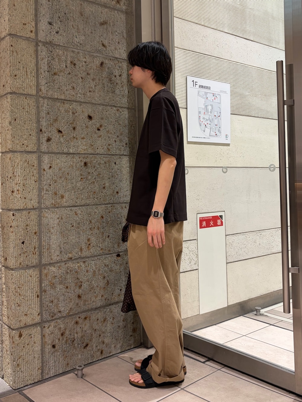 ブラウン系のTシャツ/カットソー、ベージュ系のその他パンツ、ブラック系のサンダルを着用したメンズの春コーディネートの3枚目の写真