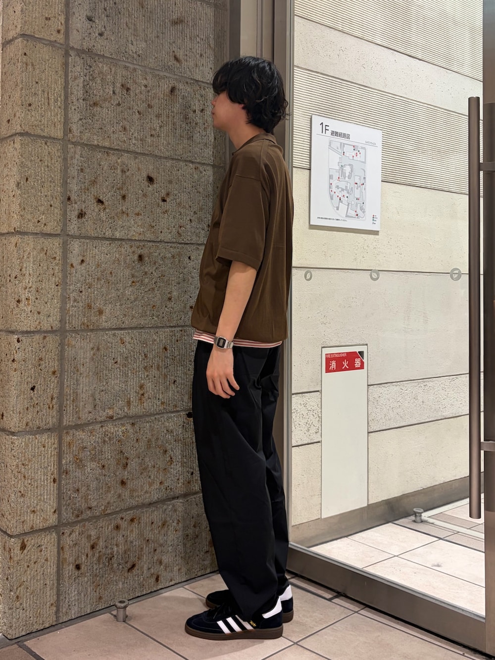 レッド系のTシャツ/カットソー、ブラウン系のニット/セーター、ブラック系のその他パンツを着用したメンズの春コーディネートの3枚目の写真