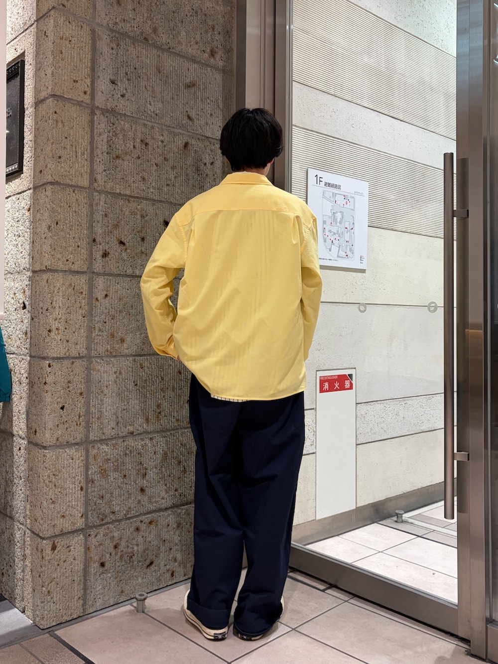 ブラック系のスニーカー、イエロー系のカバーオール、ブルー系のその他パンツを着用したメンズの春コーディネートの4枚目の写真