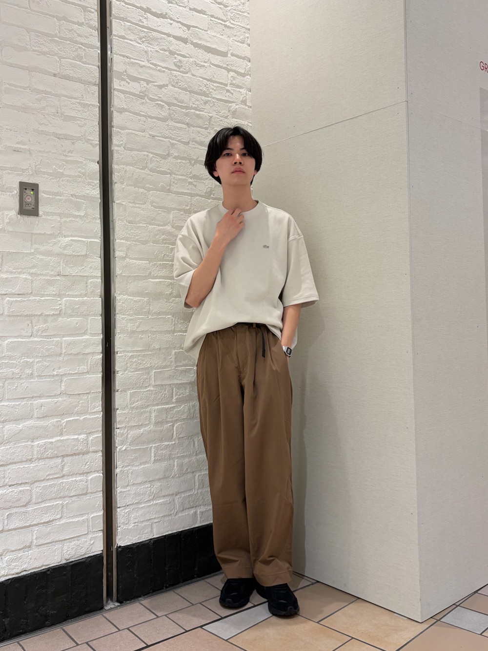 ホワイト系のTシャツ/カットソー、ブラウン系のその他パンツ、ブラック系のスニーカーを着用したメンズの春コーディネートの2枚目の写真