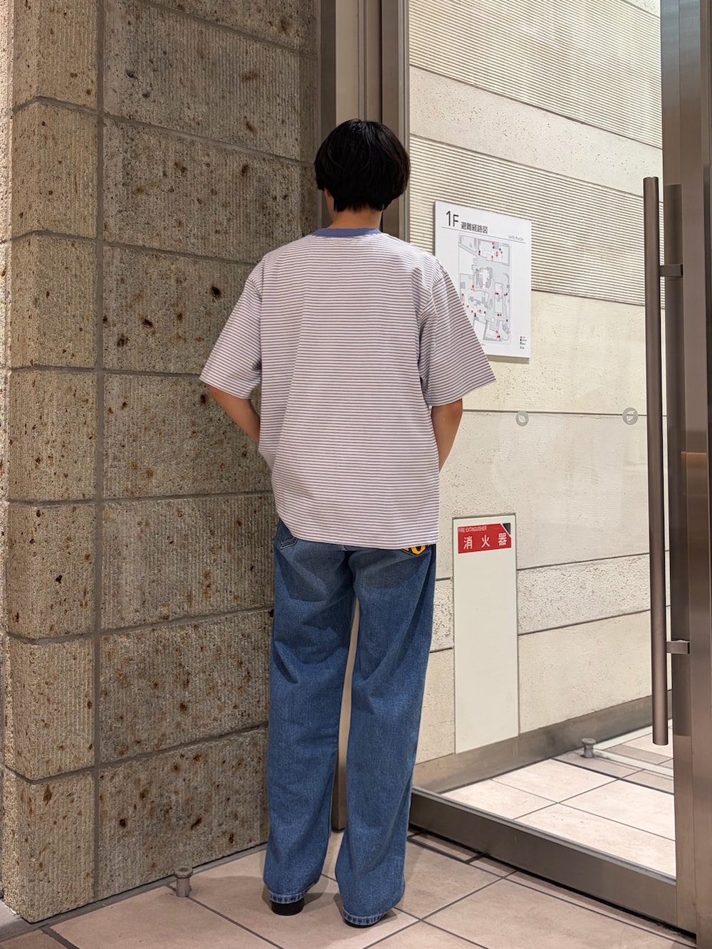 ブルー系のデニムパンツ、ブラック系のドレスシューズ、ピンク系のTシャツ/カットソーを着用したメンズの春コーディネートの3枚目の写真