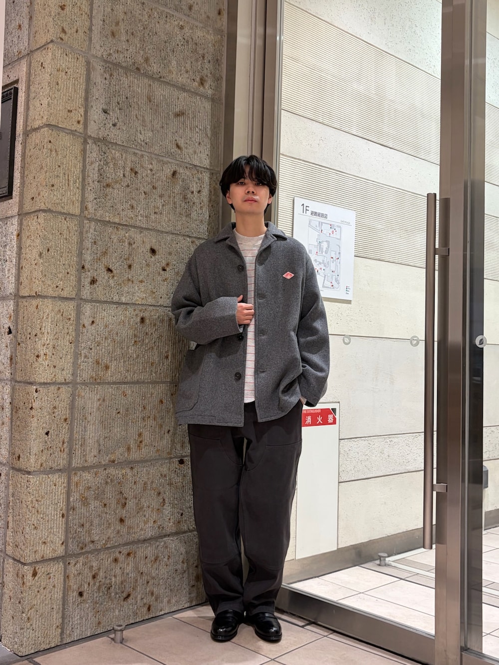 グレー系のテーラードジャケット、レッド系のTシャツ/カットソー、グレー系のその他パンツを着用したメンズの冬コーディネートの2枚目の写真