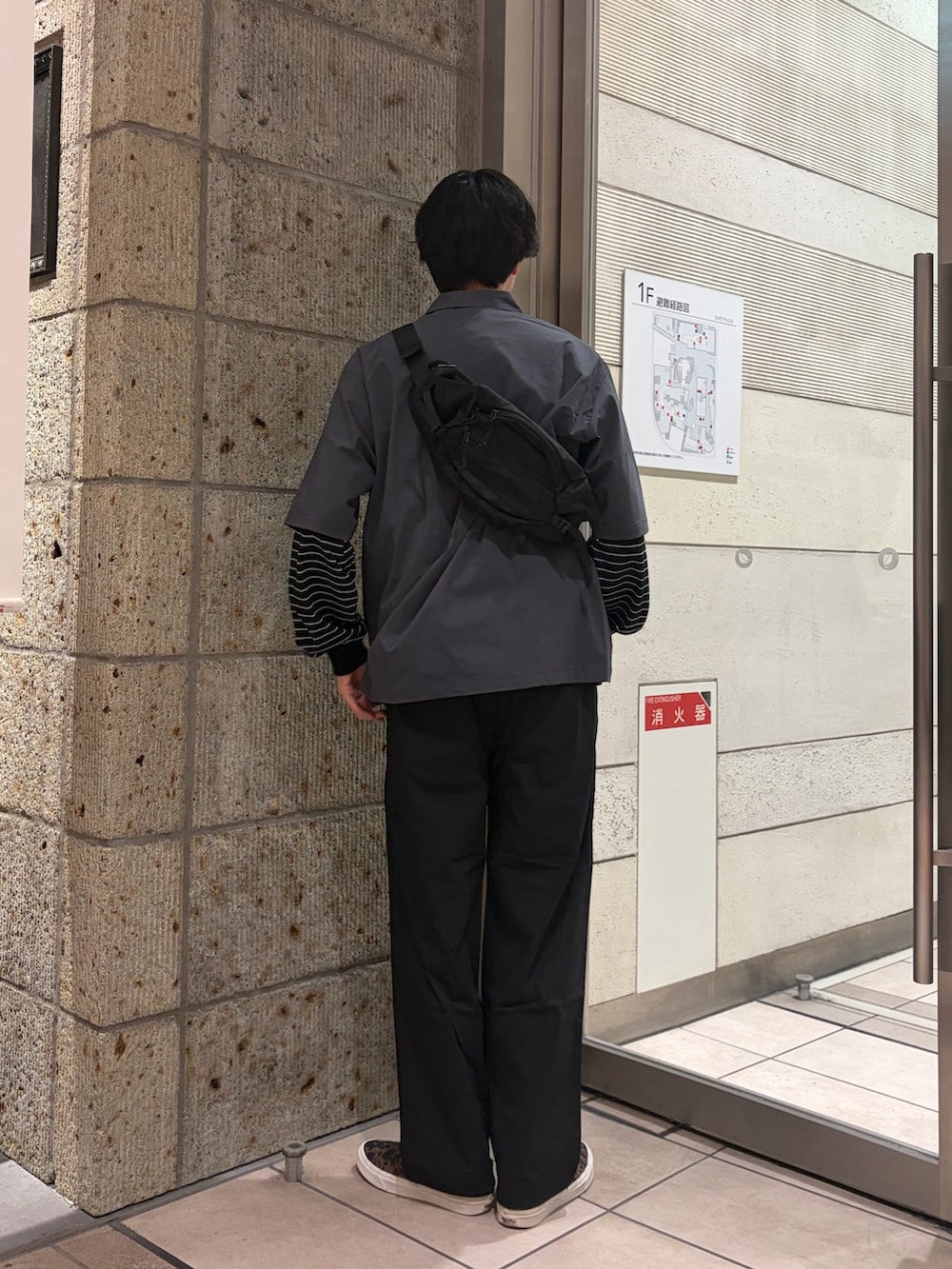 ブラウン系のスニーカー、グレー系のシャツ/ブラウス、ブラック系のショルダーバッグを着用したメンズの春コーディネートの4枚目の写真